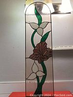 Full front view showing floral stained glass design with white flowers and brown central flower with green leaves on textured clear background.