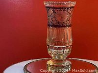 Full view of vintage cut glass vase showing clear glass with floral and leaf patterns and vertical cuts.