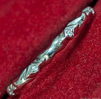 Close-up photo showcasing the engraved pattern on the polished gold ring and diamond accents.