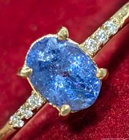 Close-up of oval tanzanite center stone and diamond-set band