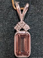 Close-up image of the rectangular emerald-cut lab diamond set in 14K white gold with three smaller natural diamonds above it.