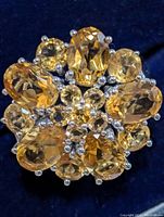 Top view close-up of the silver ring featuring multiple golden-yellow citrine stones forming a floral cluster.