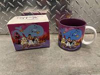 Ceramic mug and its original decorated box displayed side by side on metal surface
