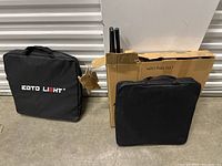Black EOTTO branded carrying case for LED ring light kit and original package box containing disassembled tripod stand with three black metal rods.