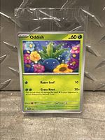 Oddish sealed promo Pokemon card in original plastic packaging, showing front of card with colorful flower field background and 60 HP.