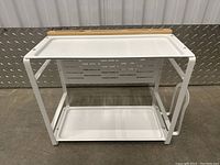 Front view of two-tier white metal spice rack with bamboo top edge and side holder