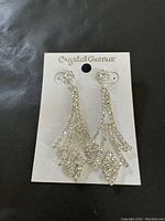 Photo of a pair of Crystal Avenue dressy formal earrings attached to the original card, displaying intricate geometric design with sparkling crystals.