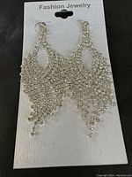 Photo of silver-tone chandelier-style dressy formal earrings on the original Fashion Jewelry card.