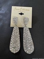 Photo of Paris Collection dressy formal rhinestone drop earrings on a beige display card with brand name.