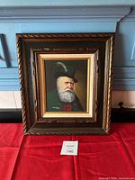 Front view of the framed oil painting showing the portrait and the dark wood frame with carving detail.