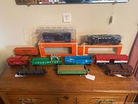 Overview of all ten cars arranged on wooden surface with two in original packaging on top row.