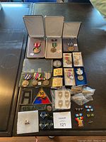 Full lot image showing all medals, patches, pins, and insignia laid out on table.