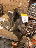 Cast iron Parker bench vise with handle and mounting base, showing overall condition and wear from use.