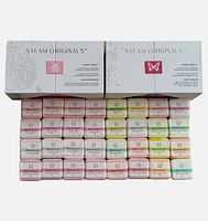 Two Steam Originals boxes with 32 shower steamers arranged in front showing various colored labels and aromatherapy blend numbers.