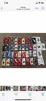 Overhead view showing all 40 sealed iPhone cases laid out on a surface in multiple rows, showcasing various colors including red, black, cream, blue, gold, and maroon.
