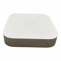 Apple AirPort Express base station angled view showing white plastic top with Apple logo and metal sides with light wear.