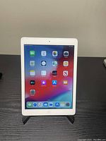 Front-facing view of iPad Air on stand showing home screen