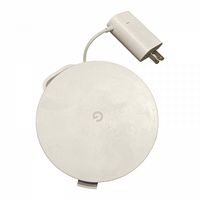 Top view of the round white Google Nest WiFi mesh router with attached power cord and power adapter plug.