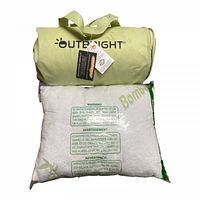 Photo of bamboo pillow sealed in plastic packaging with warning labels and green branding, alongside Outbright Nightbright pillow in light green carrying case.