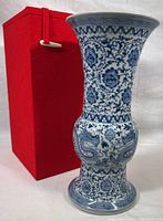 Front view of vase with red fabric cushion box in background