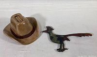 Both ceramic cowboy hat and copper bird shown side-by-side on white background