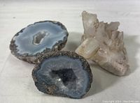 Photo showing the full set of three mineral specimens including two blue and white geodes and one crystal cluster on a white background.