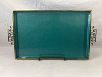 Full view of rectangular teal serving tray with gold trim and handles, placed on a white fabric background.