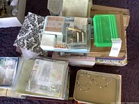 Overhead view of stacked decorative boxes, plastic bins, binders and loose crafting supplies