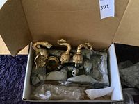 Overview of boxed faucet spout, handles, and installation parts