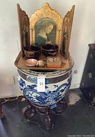 Overall view showing ceramic planter on wooden stand, tray with decorative items, and triptych screen