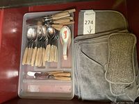 Tray holding flatware pieces, ceramic spoons, spreaders and cleaning cloths/sponges