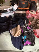 Overview of all swimwear, pants, bag and visor laid out