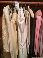 Wide view of hanging garments showing jackets, skirts, pants, sweater