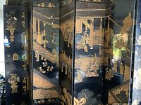 Front view of black lacquered panels with gold gilt architectural and figure scenes