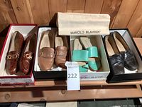 Front view of four pairs of shoes in boxes on shelf