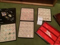 Five trays containing round dishes with loose gemstones sorted by color and cut