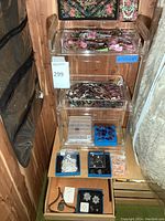 Clear acrylic shelf with three drawers filled with beads, stones, necklaces and findings