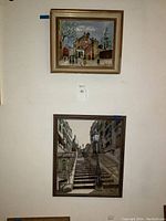 Two framed paintings hung on wall, showing both canvases together