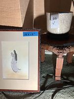 Photo of framed 16x12 inch art print and wooden table with vase on top