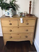 Front view of chest showing four drawers and turned knobs