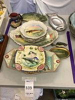 Overview of fish-themed collection showing various platters, bowls, pitcher and decorative dishes.