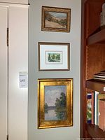 Three framed artworks displayed on wall