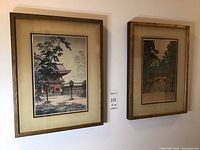 Two framed Asian prints side by side on wall