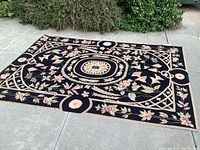 Full view of rug laid flat outdoors showing overall pattern and condition