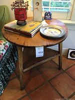 Full view of round wooden side table with decorative items on top