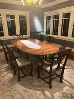Oval table with two attached leaves and eight chairs around it in dining room
