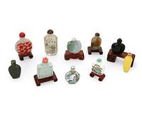 Ten snuff bottles with six wood display stands arranged in two rows.