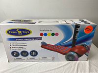 Box front showing the Fawn Toys brand and a picture of the 3-wheel junior kick scooter with red deck and black handlebar. The box highlights LED flashing wheels, 3-position handlebar, rear foot brake and durable steel frame. Also indicates recommended age 2+ and max supported weight 50 kg.