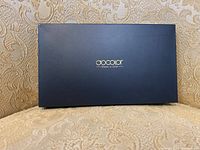 Closed black box packaging with gold 'docolor' logo.
