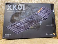 Box front showing the ProtoArc XK01 Foldable Full-Size Wireless Keyboard with tri-folding design and Bluetooth feature, suitable for business travel.